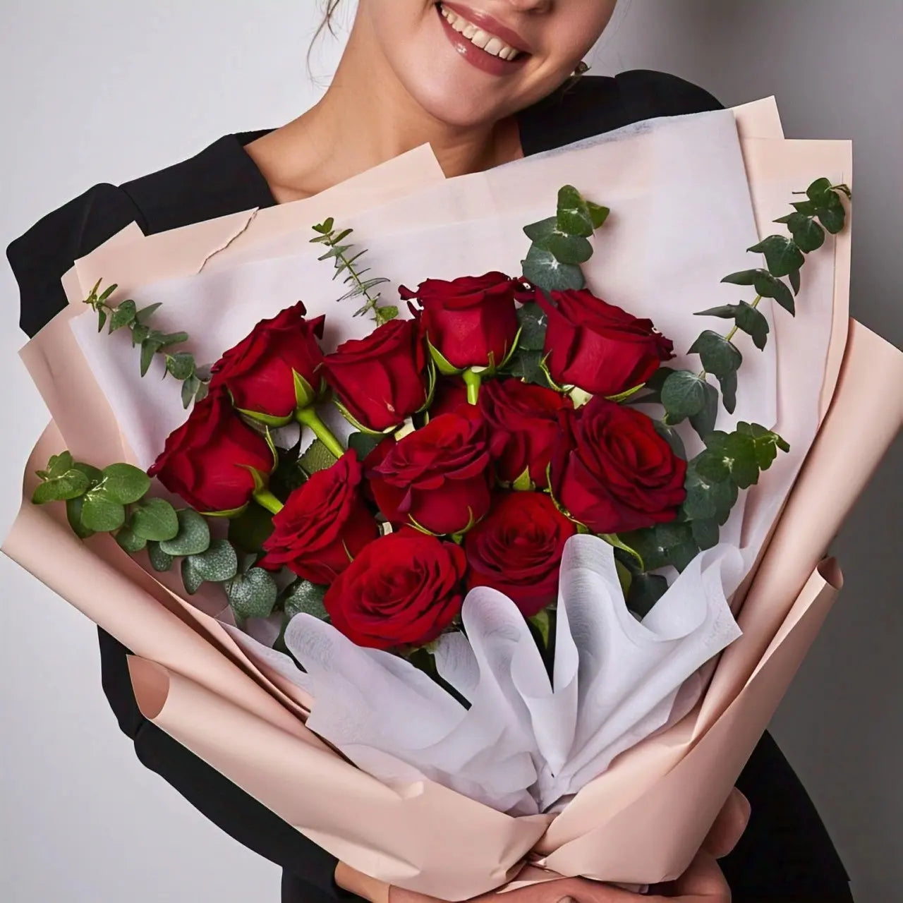 Elegant bouquet of eleven long-stemmed red roses beautifully wrapped with fresh green foliage, available for flower delivery in Hong Kong
