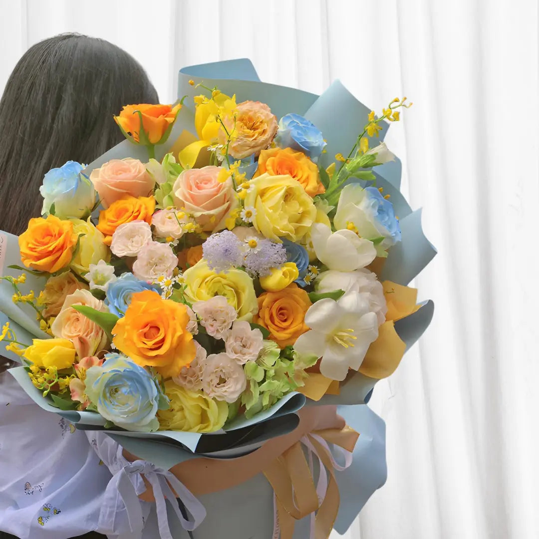 Sunset Dream Bouquet with Yellow, Pink, and Orange Roses, White Tulips, and Blue Larkspur Elegant Floral Arrangement in Hong Kong