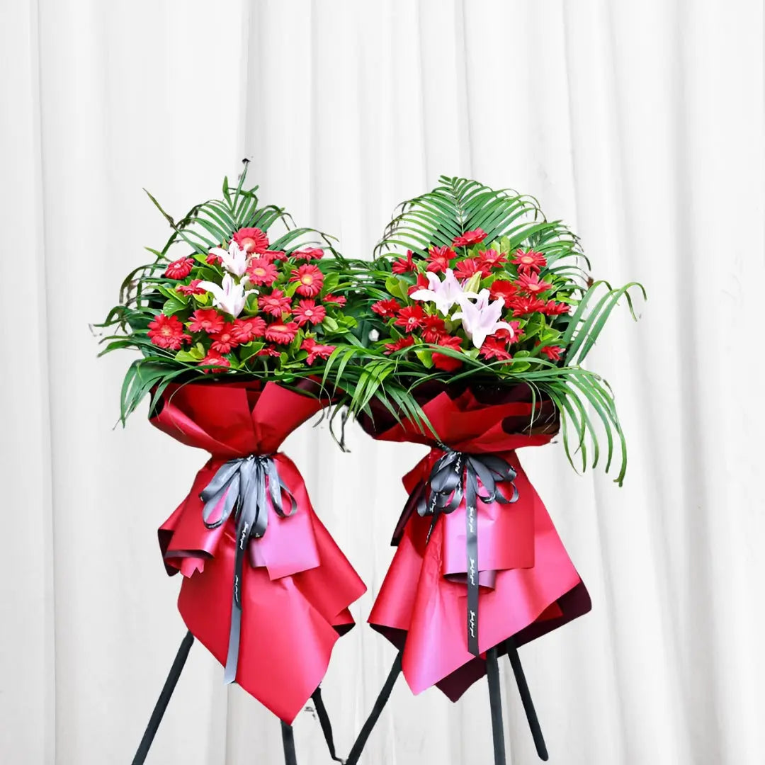 Vibrant red gerbera daisies and white lilies bouquet with palm leaves in Hong Kong